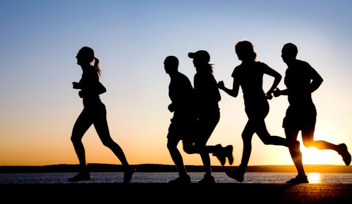 Runners silhouetted against the sun